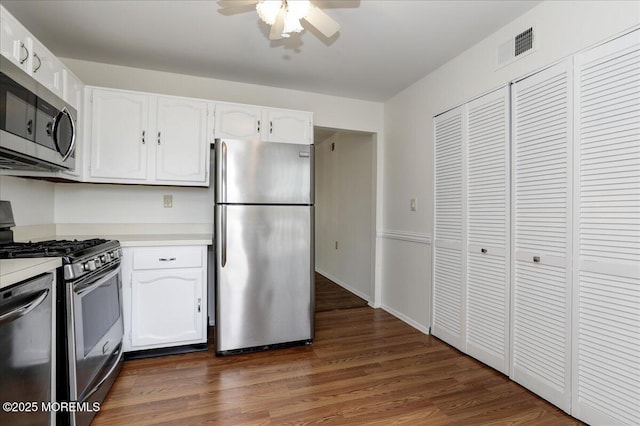 kitchen with white cabinetry, stainless steel appliances, wood finished floors, and light countertops