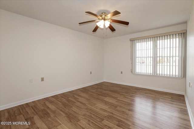 unfurnished room featuring ceiling fan, baseboards, and wood finished floors