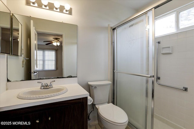 full bathroom with ceiling fan, a stall shower, vanity, and toilet