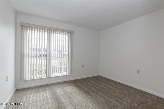 spare room with carpet and baseboards