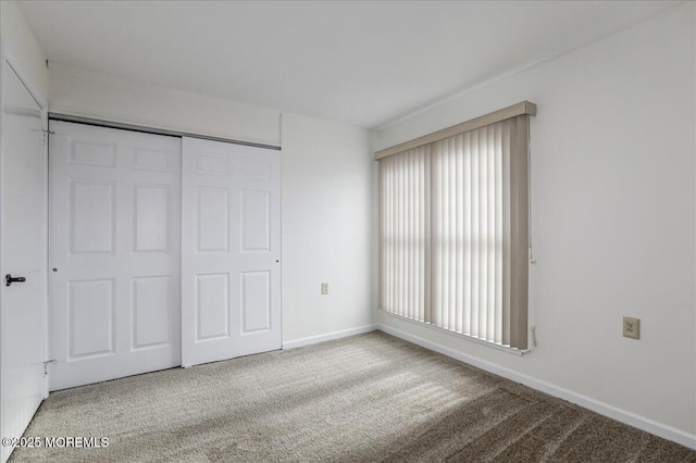 unfurnished bedroom with carpet, baseboards, and a closet