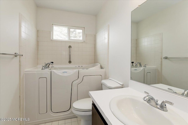 bathroom featuring tile patterned floors, vanity, toilet, and a bath