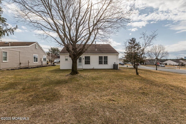 rear view of house featuring a lawn and cooling unit