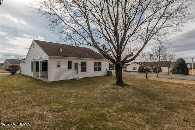 back of house with a yard and central AC unit