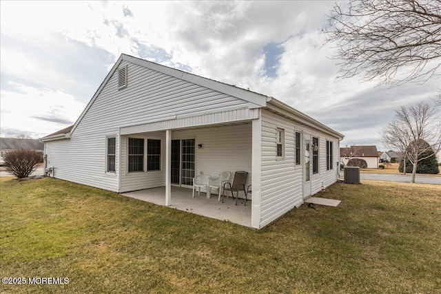 back of property featuring a patio area, a yard, and central AC