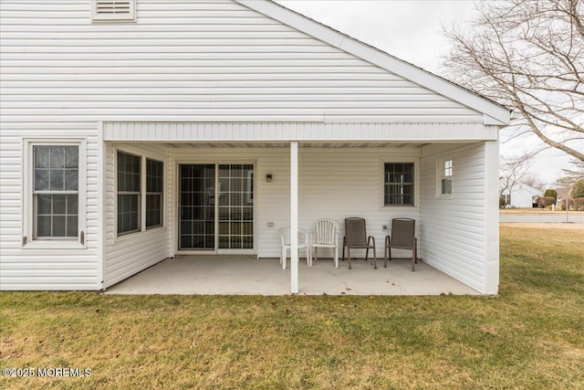 back of house with a lawn and a patio area