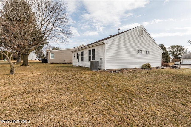 back of house with central AC and a lawn