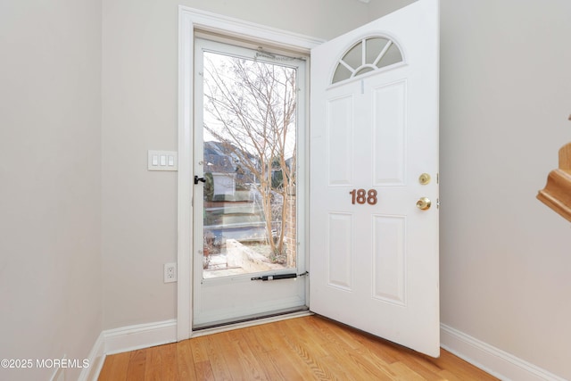 doorway to outside featuring light wood-style flooring and baseboards