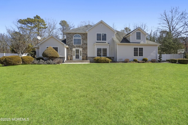 traditional home featuring stone siding, fence, and a front lawn