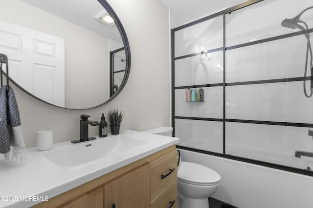 bathroom featuring bath / shower combo with glass door, vanity, and toilet