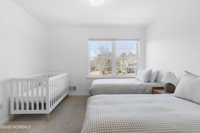 carpeted bedroom featuring visible vents and baseboards