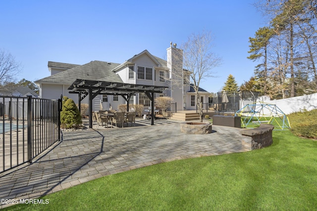 back of house with a trampoline, a patio, fence, and a pergola