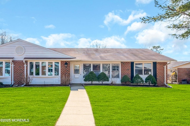 single story home with a front yard and brick siding