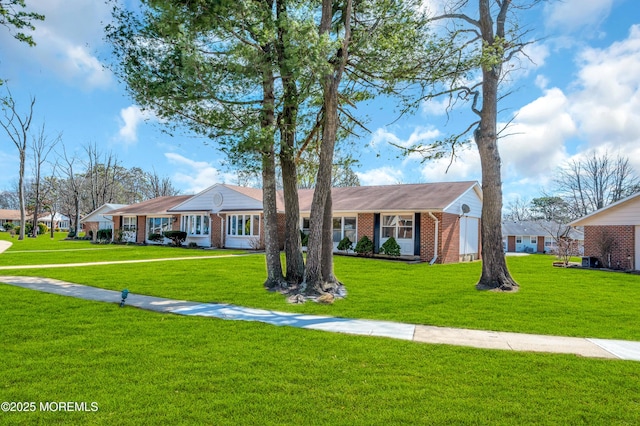 view of front of property featuring a front yard and brick siding