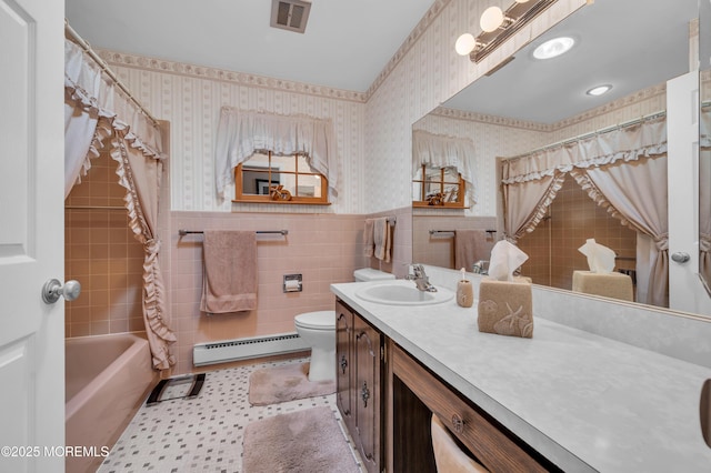 bathroom featuring a wainscoted wall, a baseboard heating unit, visible vents, and wallpapered walls