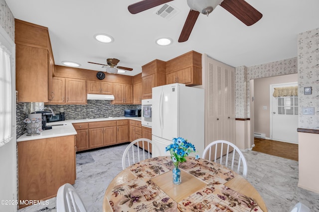 kitchen featuring under cabinet range hood, visible vents, marble finish floor, light countertops, and freestanding refrigerator