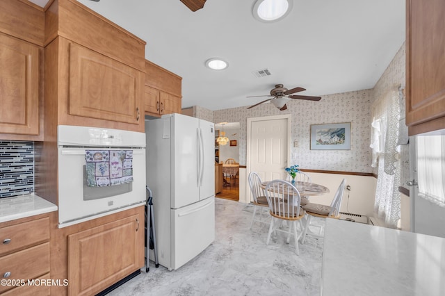 kitchen with light countertops, white appliances, visible vents, and wallpapered walls