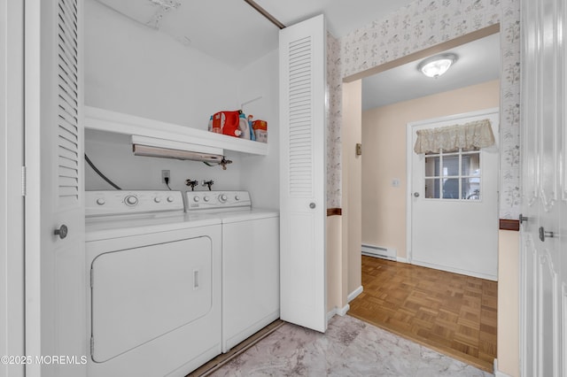 washroom featuring laundry area, separate washer and dryer, baseboard heating, and baseboards