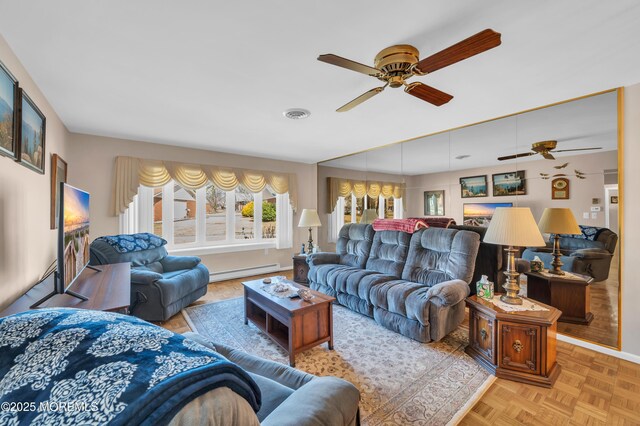 living room with ceiling fan, baseboard heating, visible vents, and baseboards