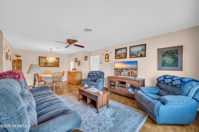 living area featuring baseboards, visible vents, and a ceiling fan