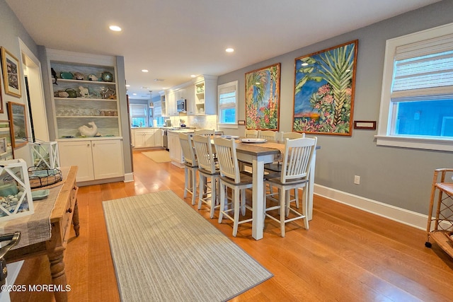 dining room featuring light wood-style flooring, recessed lighting, and baseboards