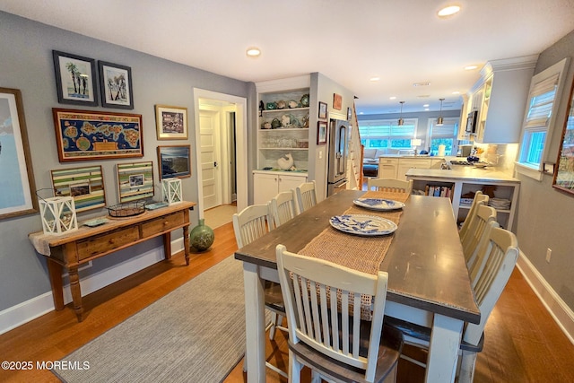 dining space with recessed lighting, wood finished floors, and baseboards