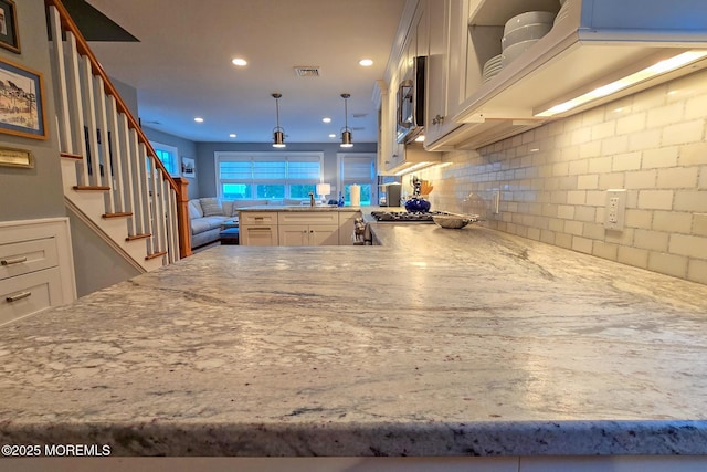 kitchen featuring visible vents, open floor plan, decorative backsplash, recessed lighting, and a peninsula