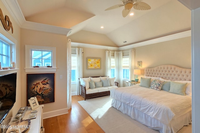 bedroom with vaulted ceiling, multiple windows, wood finished floors, and baseboards