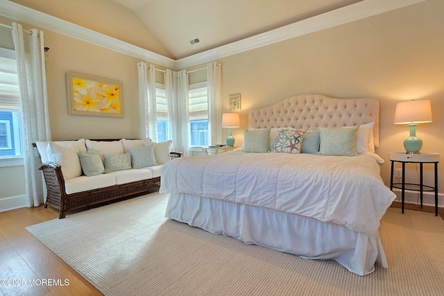 bedroom featuring vaulted ceiling, wood finished floors, visible vents, and baseboards