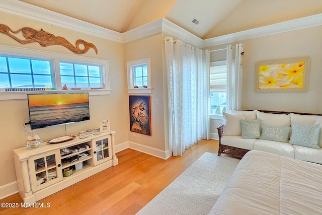 living area featuring a wealth of natural light, wood finished floors, and vaulted ceiling