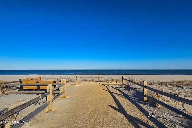 water view with fence and a beach view