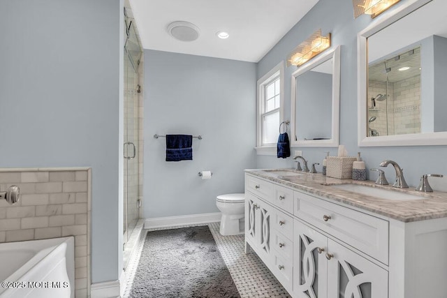 bathroom featuring double vanity, a shower stall, and a sink