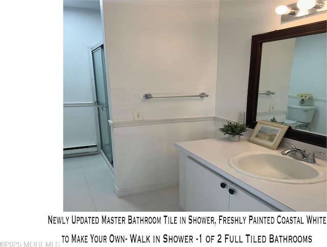 bathroom with a stall shower, a baseboard heating unit, tile patterned flooring, and vanity