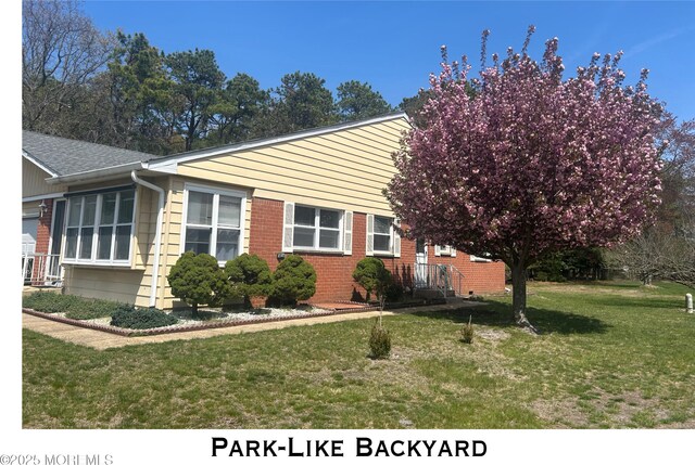 view of property exterior featuring a lawn and brick siding