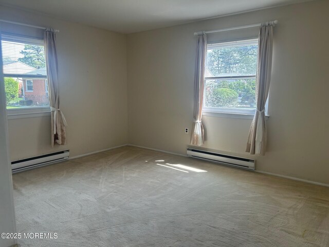 unfurnished room with a baseboard radiator, a healthy amount of sunlight, and carpet