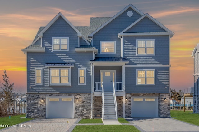 view of front of home featuring stairway, driveway, metal roof, and a standing seam roof