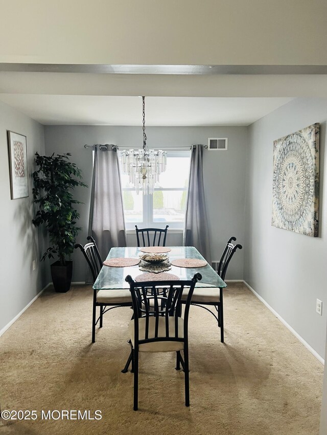 dining room with visible vents, carpet floors, baseboards, and a chandelier