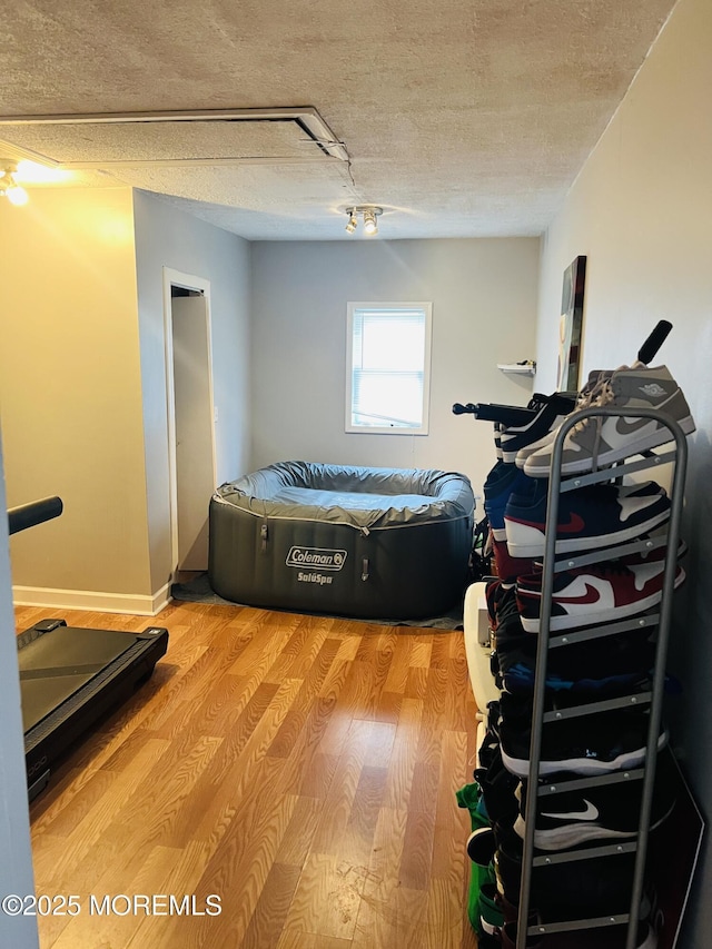 bedroom with light wood-type flooring and a textured ceiling