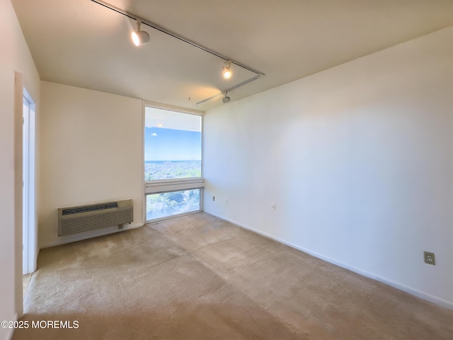 spare room with carpet floors, floor to ceiling windows, a wall mounted air conditioner, and track lighting