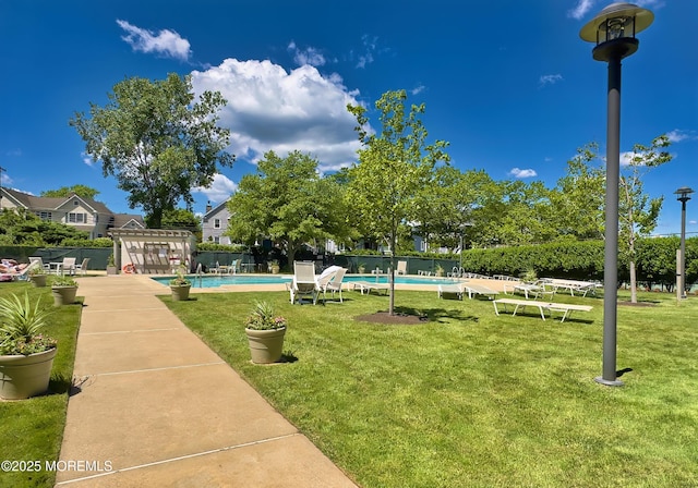 surrounding community with a swimming pool, a lawn, and fence