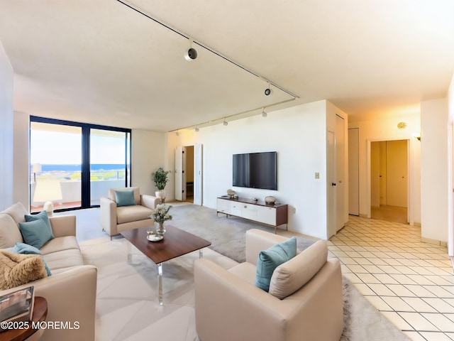 living room with expansive windows, track lighting, and light tile patterned floors