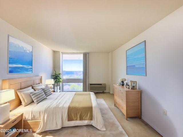 bedroom featuring light carpet and a wall mounted air conditioner