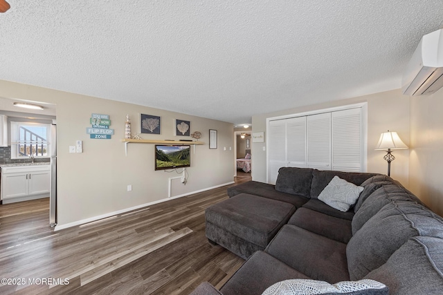 5909 Ocean Blvd, Long Beach Twp, NJ 08008 - living room with dark wood-type flooring, baseboards, a wall mounted air conditioner, and a textured ceiling