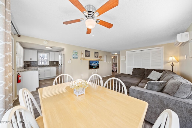 5909 Ocean Blvd, Long Beach Twp, NJ 08008 - dining room featuring an AC wall unit, a ceiling fan, and wood finished floors