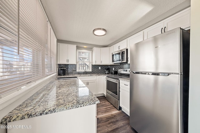 5909 Ocean Blvd, Long Beach Twp, NJ 08008 - kitchen featuring backsplash, dark wood-style floors, white cabinets, stainless steel appliances, and a sink