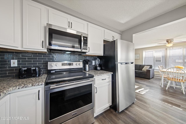 5909 Ocean Blvd, Long Beach Twp, NJ 08008 - kitchen with backsplash, stainless steel appliances, dark wood-style floors, white cabinets, and a textured ceiling