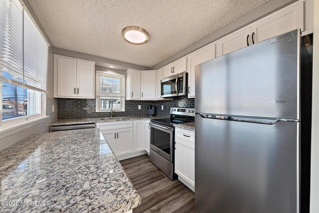 5909 Ocean Blvd, Long Beach Twp, NJ 08008 - kitchen with dark wood-style floors, appliances with stainless steel finishes, white cabinetry, and a sink