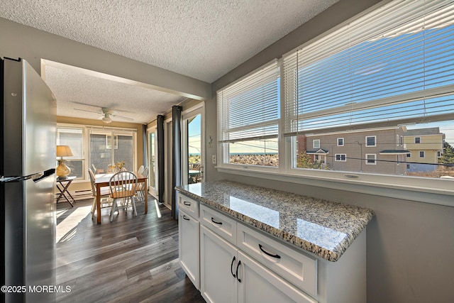 5909 Ocean Blvd, Long Beach Twp, NJ 08008 - kitchen featuring light stone countertops, freestanding refrigerator, dark wood-type flooring, a textured ceiling, and white cabinetry