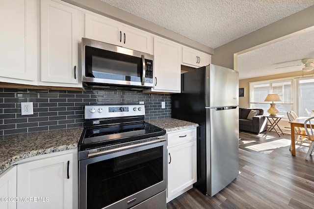 5909 Ocean Blvd, Long Beach Twp, NJ 08008 - kitchen featuring a textured ceiling, dark wood-style floors, white cabinetry, stainless steel appliances, and stone counters