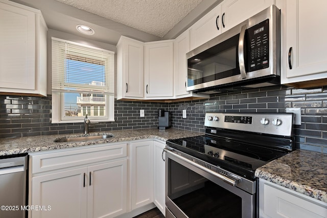5909 Ocean Blvd, Long Beach Twp, NJ 08008 - kitchen with a sink, stainless steel appliances, light stone countertops, and white cabinetry